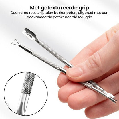 Hand houdt twee roestvrijstalen manicure gereedschappen met getextureerde grip vast