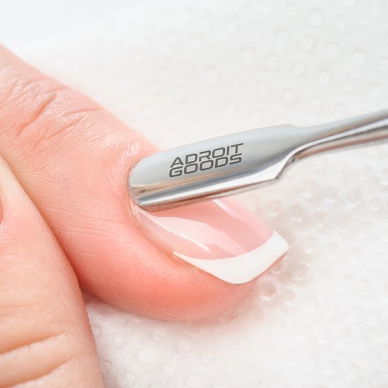 Close-up van professioneel nagelriemverzorgingsgereedschap op een vinger met verzorgde nagel