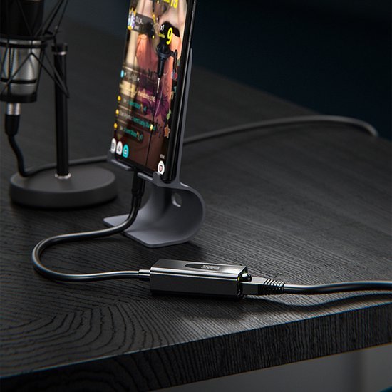 Draadloze microfoonverbinding en smartphone op een zwart bureau met USB-adapter
