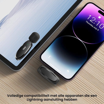 Draadloze microfoon aangesloten op tablet en smartphone met oplaaddock op houten oppervlak