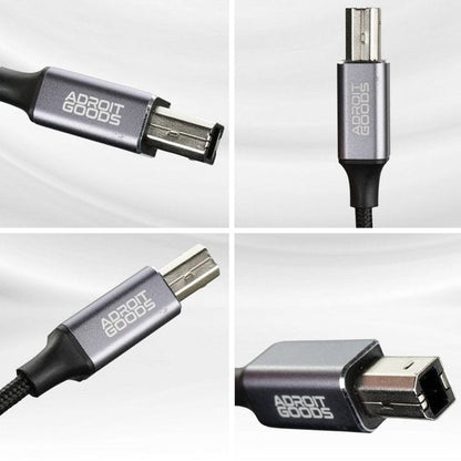 Close-up van een grijze connector met geweven kabel en zichtbare merknaam Adroit Goods