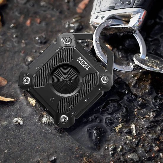 zwarte vierkante sleutelhanger met metalen ring en AdroitGoods logo op natte steenvloer