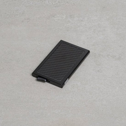 Zwart slank compact portemonnee met een geribbeld oppervlak en een schuifknop