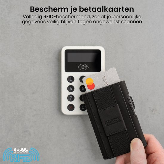 Hand met zwarte RFID-portemonnee houdt betaalkaart voor witte betaalterminal op grijze achtergrond