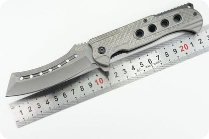 vouwmes met metalen handvat en geperforeerd lemmet naast een metalen liniaal