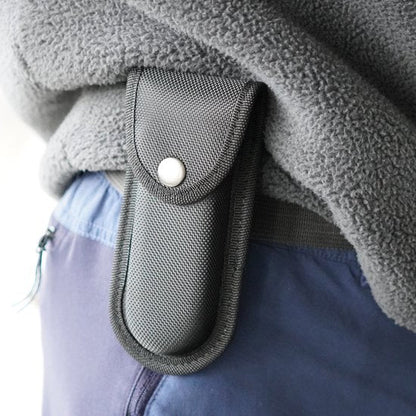 Zwart draaghoesje met knoopsluiting bevestigd aan riem van persoon met fleece trui