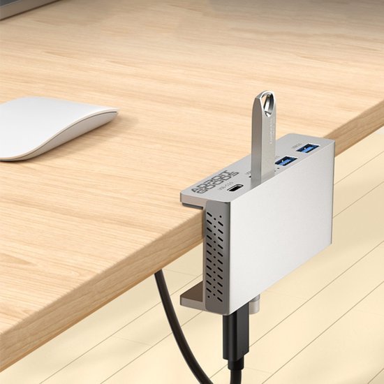 Aluminium USB-hub met meerdere poorten bevestigd aan houten bureau met aangesloten kabels