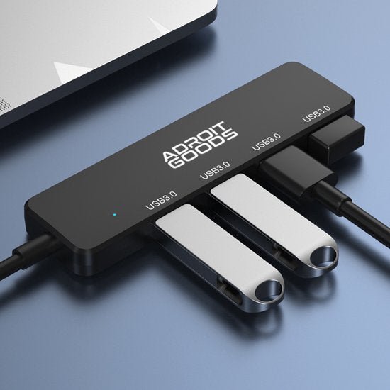 Zwarte USB 3.0 hub met vier poorten en meerdere aangesloten USB-sticks en kabels naast laptop