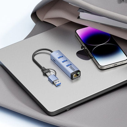 USB-hub met meerdere poorten en ethernet aansluiting naast laptop en smartphone op stoffen ondergrond