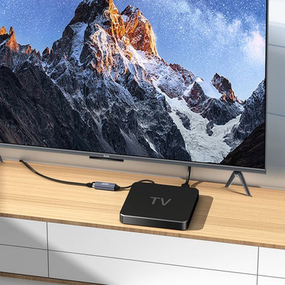 TV-box aangesloten op een moderne televisie met berglandschap op het scherm geplaatst op houten meubel