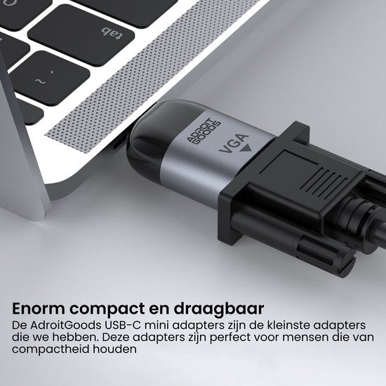 Close-up van een USB-C adapter en VGA kabel verbonden met een laptop in zilver en zwart.