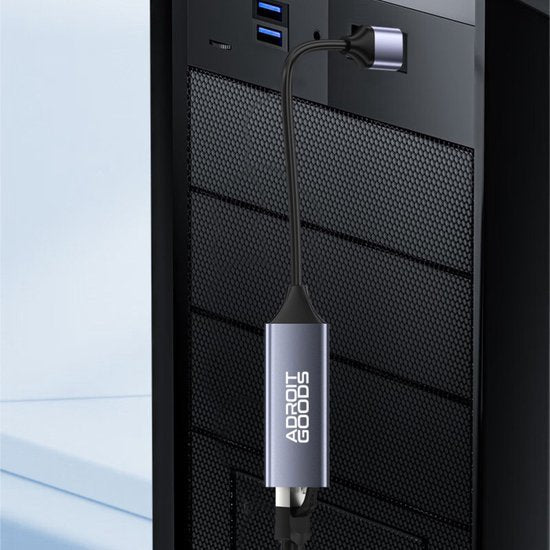 zwarte en zilveren usb extender met AdroitGoods logo aangesloten op een pc kast