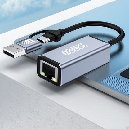 compact zilverkleurig adapter met usb en ethernet aansluiting op laptoprand geplaatst