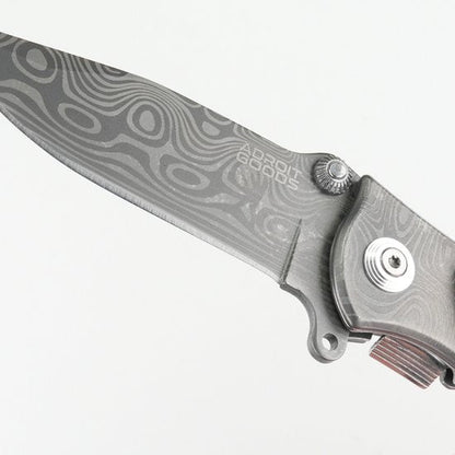 gevouwen mes met decoratief patroon en metalen handgreep in grijstinten